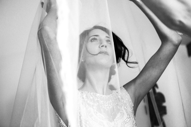 La mariée met son voile. The bride is putting on her veil.